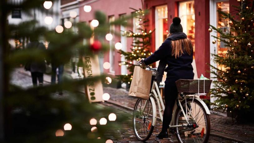 A girl rides a bike through a Christmassy street in Aarhus, Denmark