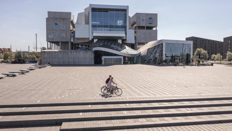 Fietsers passeren het Musikkens Hus in Aalborg in Noord-Jutland