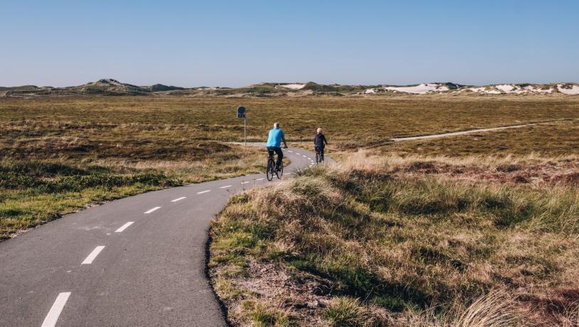 To personer, der cykler på en landevej i Hvide Sande