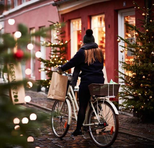 A girl rides a bike through a Christmassy street in Aarhus, Denmark