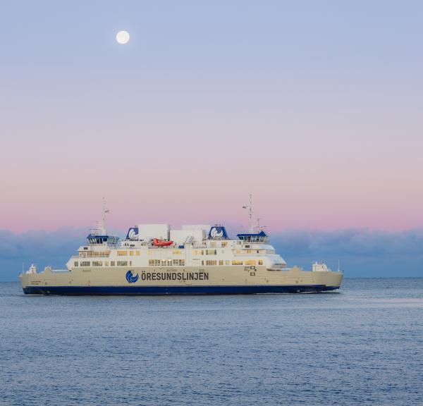 Öresundslinjens färja i horisonten som kryssar över havet vid solnedgång.