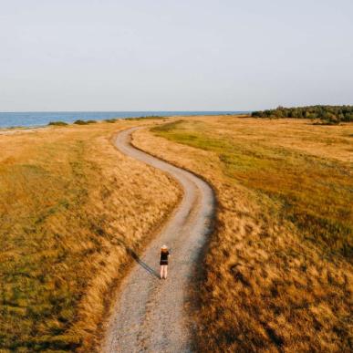 Kvinne står på en landevei på Endelave, Kystlandet, Danmark