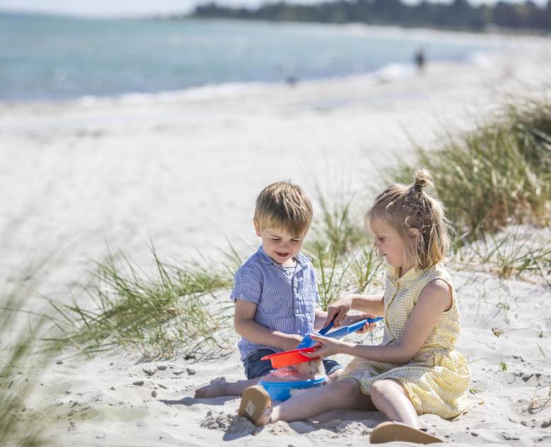 Barn leker i sanden ved Saksild Strand i Kystlandet, Danmark